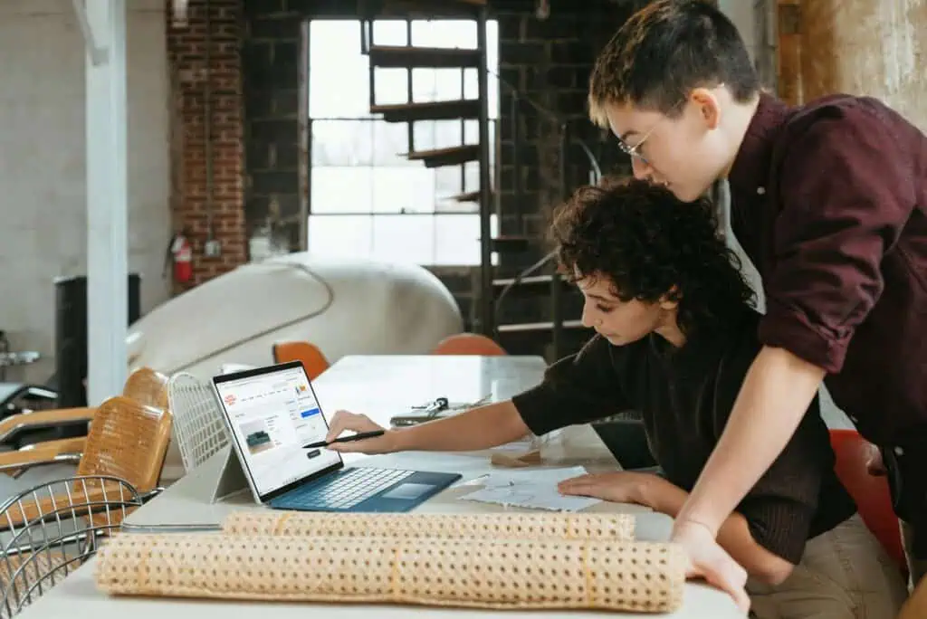 Small business owners reviewing a website redesign on a laptop